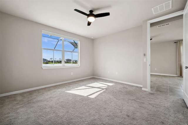 spare room with a ceiling fan, baseboards, visible vents, and carpet flooring