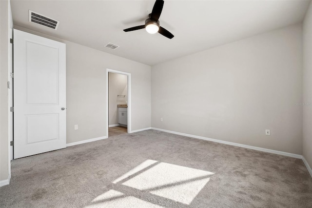 unfurnished bedroom with ensuite bathroom, carpet flooring, visible vents, and baseboards