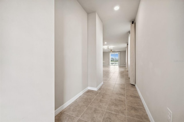 hall with recessed lighting, baseboards, and light tile patterned floors