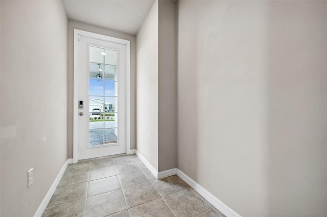 doorway to outside featuring light tile patterned floors and baseboards