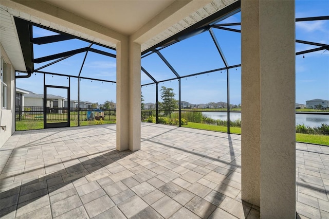 view of patio featuring a water view and glass enclosure