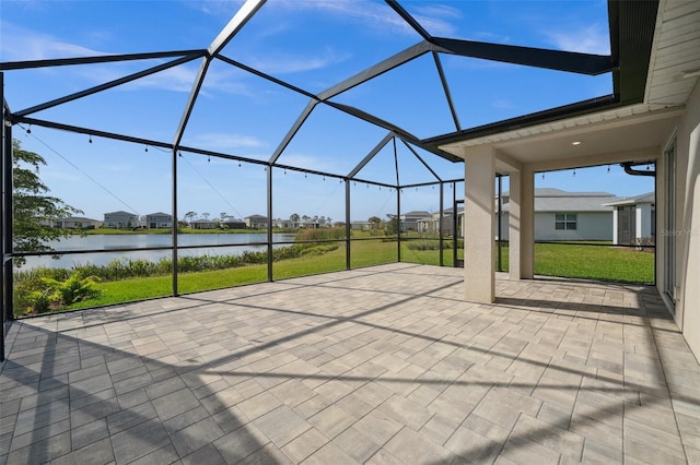 view of patio / terrace featuring glass enclosure and a water view