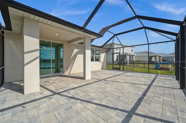 view of patio / terrace with glass enclosure, a residential view, and fence