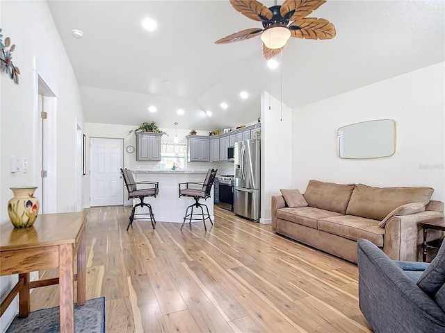 living area with a ceiling fan, light wood-type flooring, vaulted ceiling, and recessed lighting