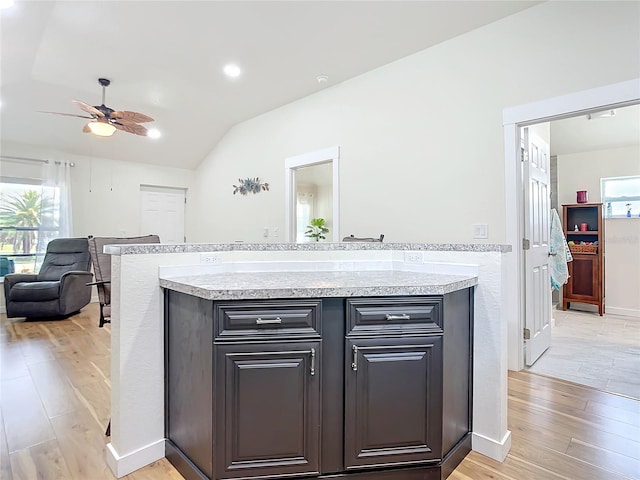 kitchen featuring vaulted ceiling, light countertops, a healthy amount of sunlight, and light wood-style floors