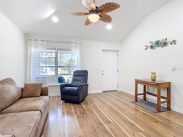 living room featuring light wood finished floors, ceiling fan, baseboards, and vaulted ceiling