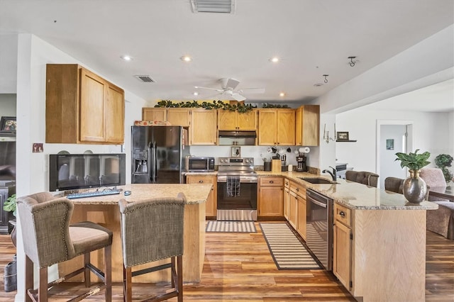 kitchen with a peninsula, light wood-type flooring, visible vents, and stainless steel appliances