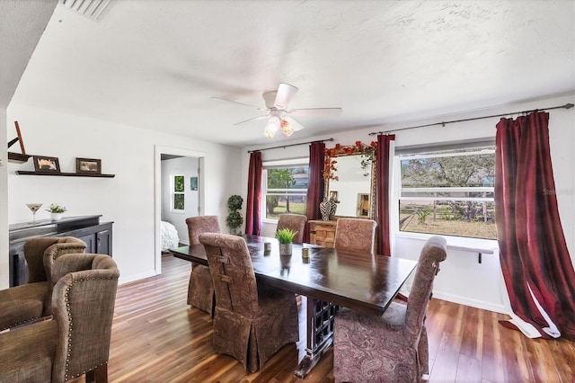 dining space featuring visible vents, wood finished floors, a ceiling fan, and baseboards