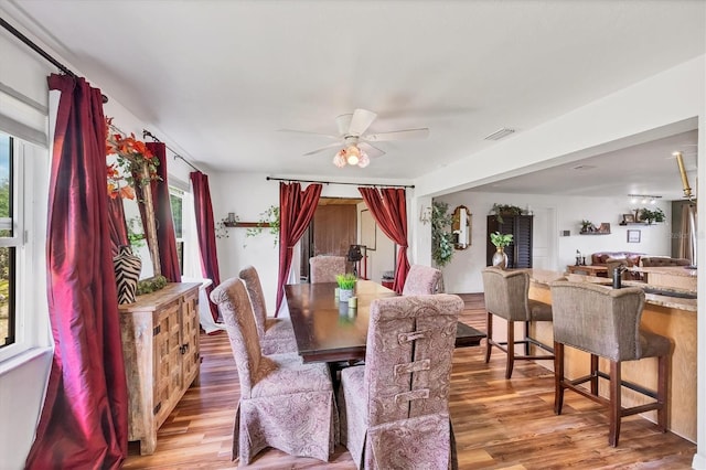 dining space featuring ceiling fan, visible vents, and wood finished floors