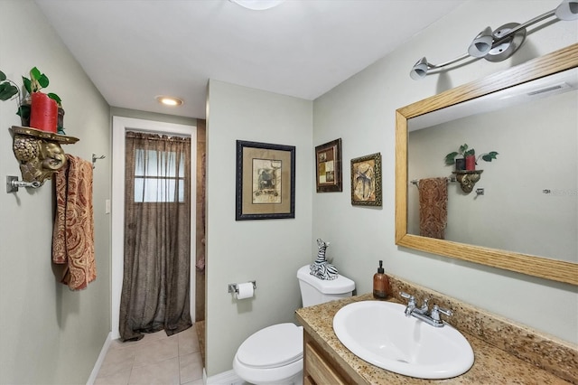 bathroom with baseboards, vanity, toilet, and tile patterned floors