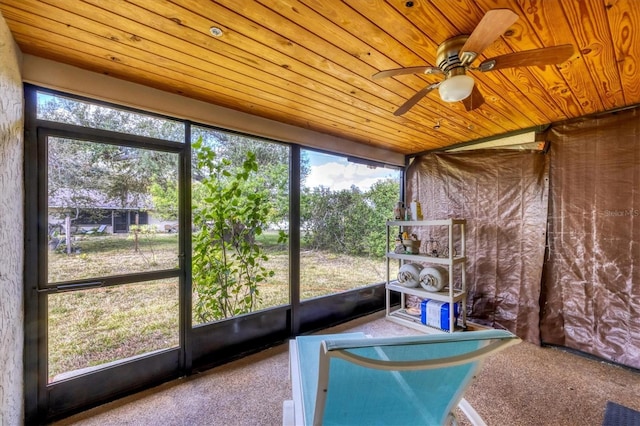 unfurnished sunroom featuring a ceiling fan and wood ceiling