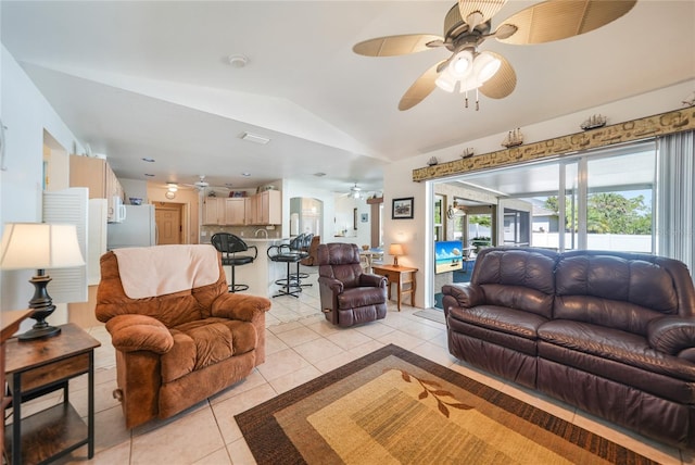 living area with lofted ceiling, light tile patterned floors, and ceiling fan