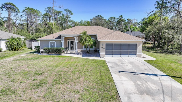 ranch-style house featuring a front yard, fence, driveway, an attached garage, and stucco siding