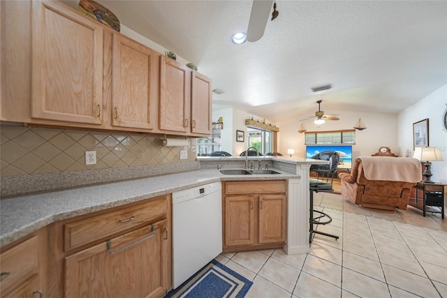 kitchen with a sink, open floor plan, a peninsula, light tile patterned floors, and dishwasher