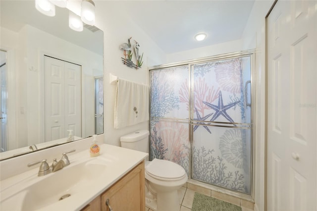 bathroom with vanity, tile patterned flooring, a shower stall, a closet, and toilet