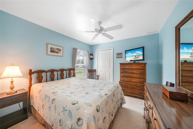 bedroom with light carpet, ceiling fan, and a closet