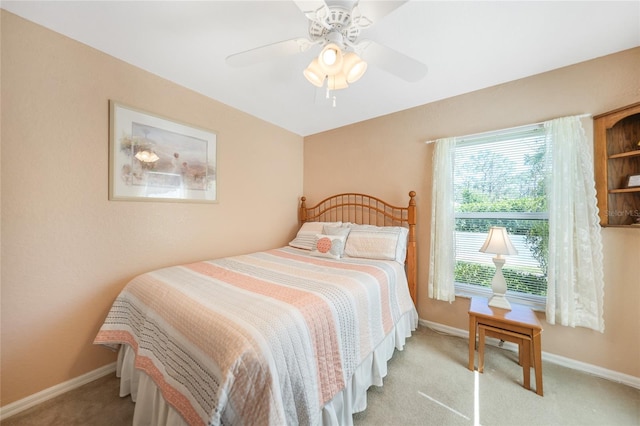 bedroom with a ceiling fan, baseboards, and light carpet