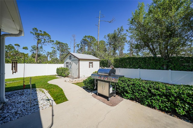 view of patio featuring a fenced backyard, a storage shed, a grill, and an outdoor structure