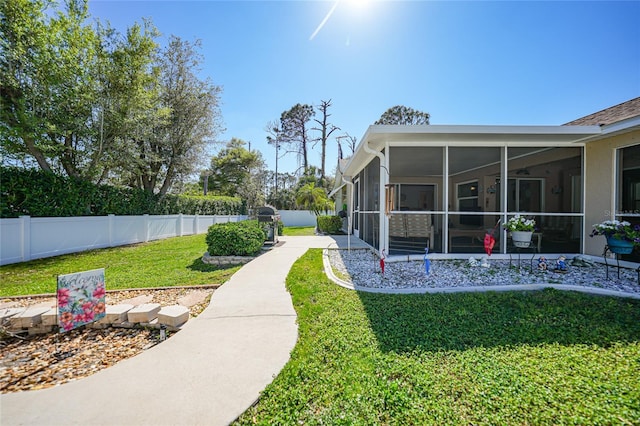 view of yard with a fenced backyard and a sunroom