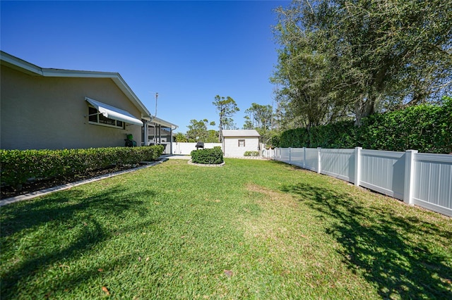 view of yard featuring an outbuilding, a storage unit, and a fenced backyard