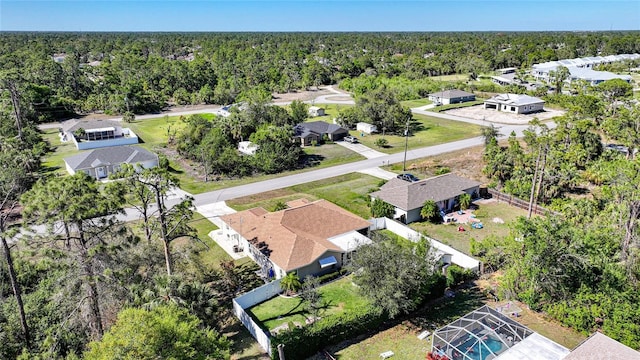 drone / aerial view featuring a wooded view and a residential view