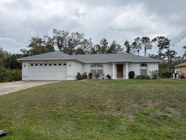 single story home featuring driveway, a garage, a front lawn, and stucco siding