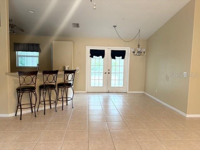 dining room featuring a wealth of natural light, french doors, visible vents, and light tile patterned floors