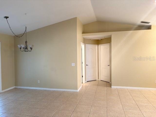 empty room featuring light tile patterned floors, baseboards, visible vents, an inviting chandelier, and vaulted ceiling