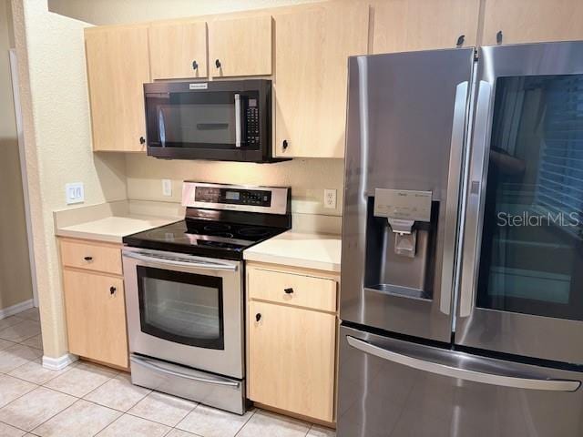 kitchen with stainless steel appliances, light countertops, and light brown cabinets