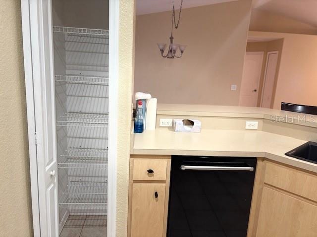 kitchen with light countertops, dishwasher, and light brown cabinetry