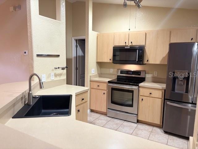 kitchen featuring black microwave, light brown cabinets, refrigerator with ice dispenser, and stainless steel electric stove