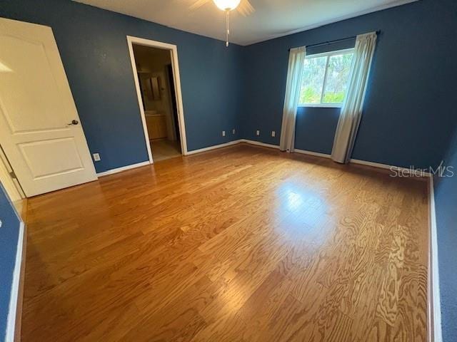 empty room with baseboards and wood finished floors