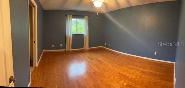 unfurnished room featuring a ceiling fan, baseboards, and wood finished floors