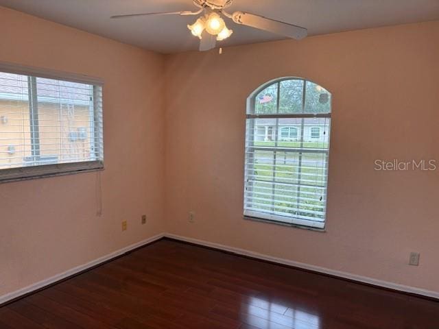 empty room featuring ceiling fan, wood finished floors, and baseboards