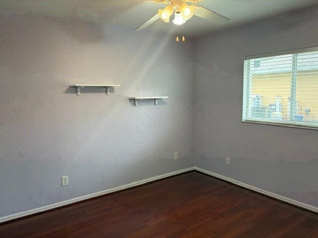 spare room featuring a ceiling fan, baseboards, and wood finished floors