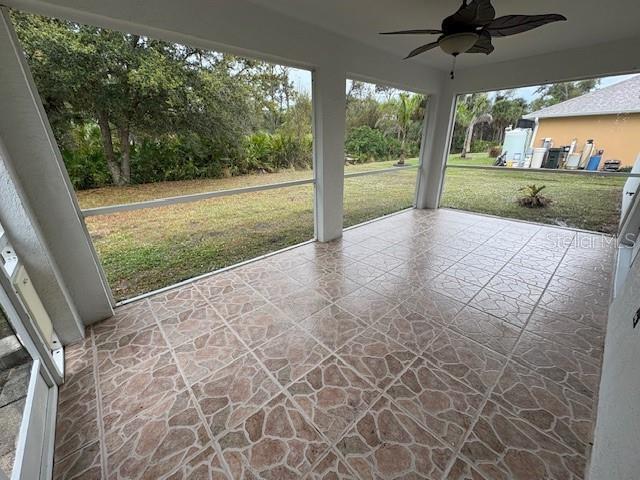 unfurnished sunroom with ceiling fan