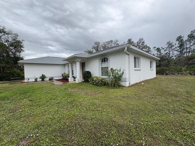 view of front of house featuring a front lawn and stucco siding