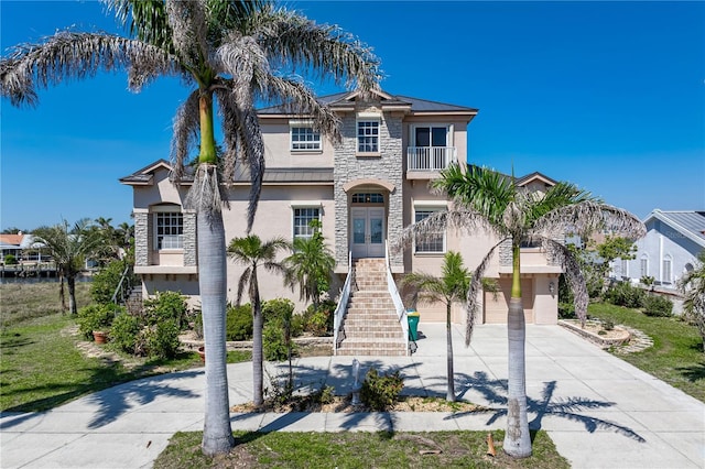 250 George Rd SE, Port Charlotte, FL 33952 - view of front of home with french doors, stucco siding, concrete driveway, stairway, and stone siding