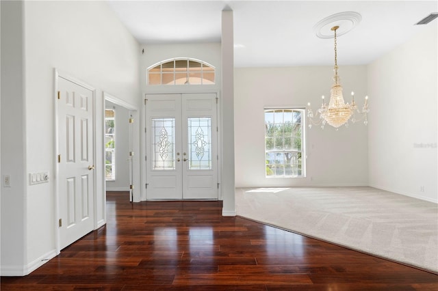 entryway with a notable chandelier, wood finished floors, visible vents, baseboards, and french doors