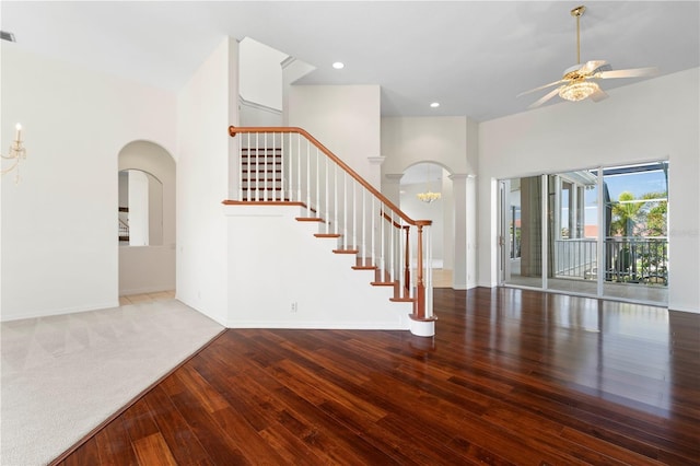 entryway featuring arched walkways, wood finished floors, stairs, ceiling fan with notable chandelier, and recessed lighting