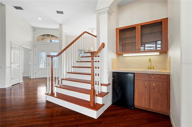 interior space with refrigerator, a sink, visible vents, dark wood-style floors, and tasteful backsplash