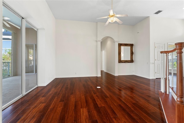 spare room with arched walkways, ceiling fan, wood-type flooring, and visible vents