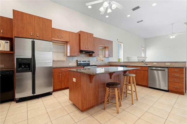 kitchen featuring stainless steel appliances, visible vents, light tile patterned flooring, ceiling fan, and under cabinet range hood