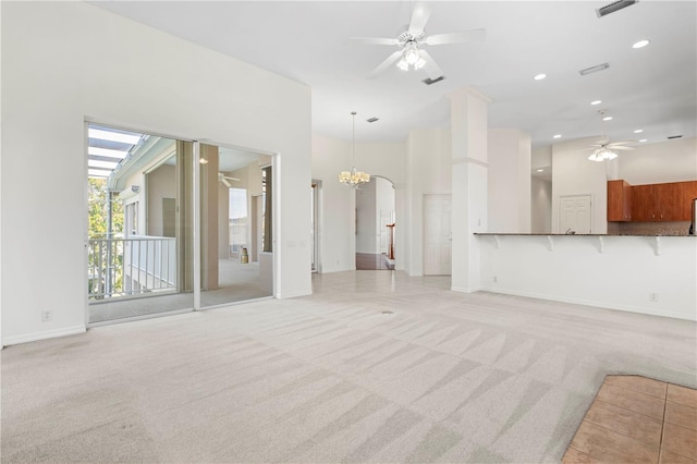 unfurnished living room featuring light carpet, recessed lighting, visible vents, and ceiling fan with notable chandelier