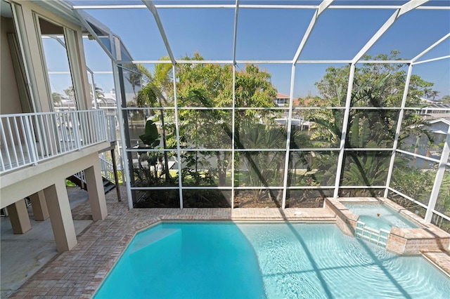 view of swimming pool featuring a patio area, a lanai, and a pool with connected hot tub