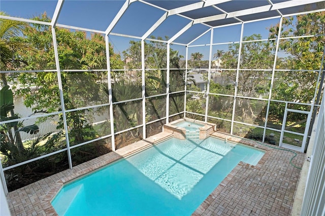 view of swimming pool featuring a patio area, glass enclosure, and a pool with connected hot tub