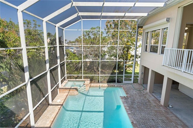 view of pool with a pool with connected hot tub, a lanai, and a patio