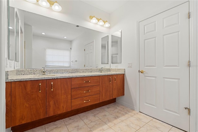 bathroom featuring tile patterned floors, a sink, and double vanity