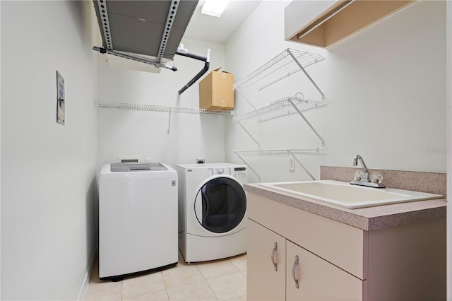 washroom with washer and dryer, cabinet space, a sink, and light tile patterned floors