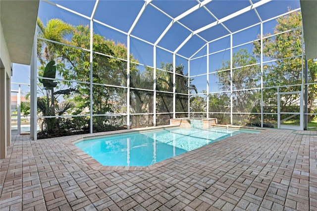 view of pool with glass enclosure, a patio, and a pool with connected hot tub